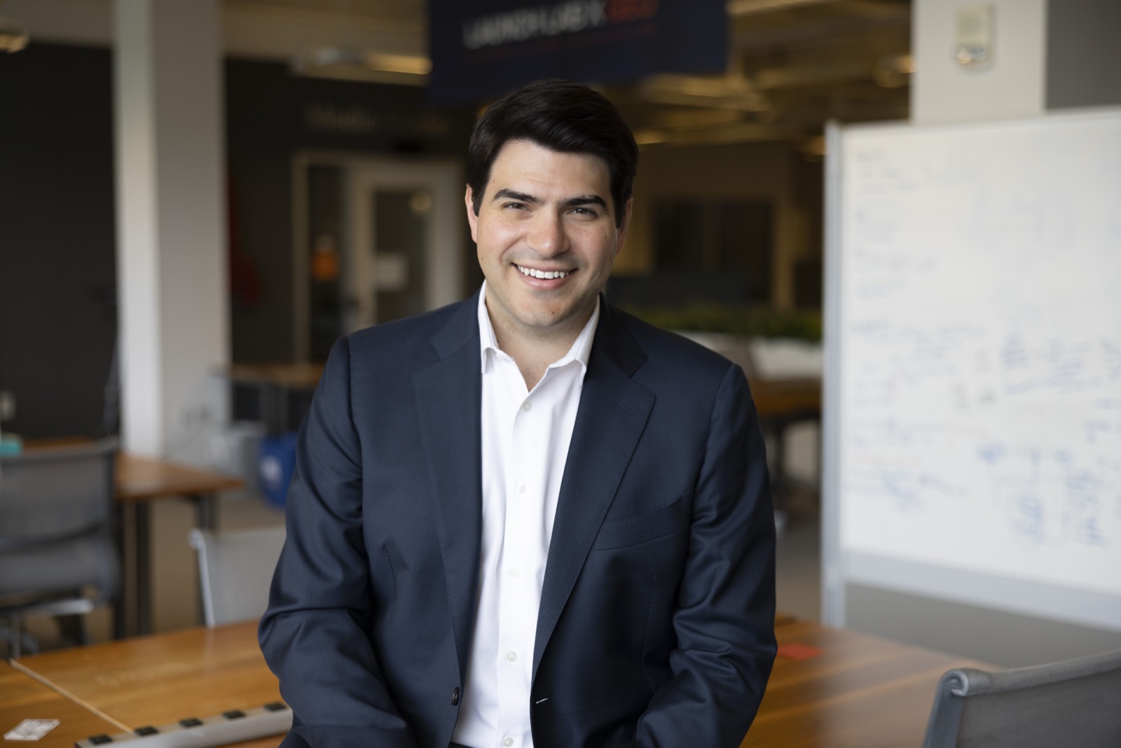 Philippe Rival, smiling, in a navy blazer in the Enlaye office