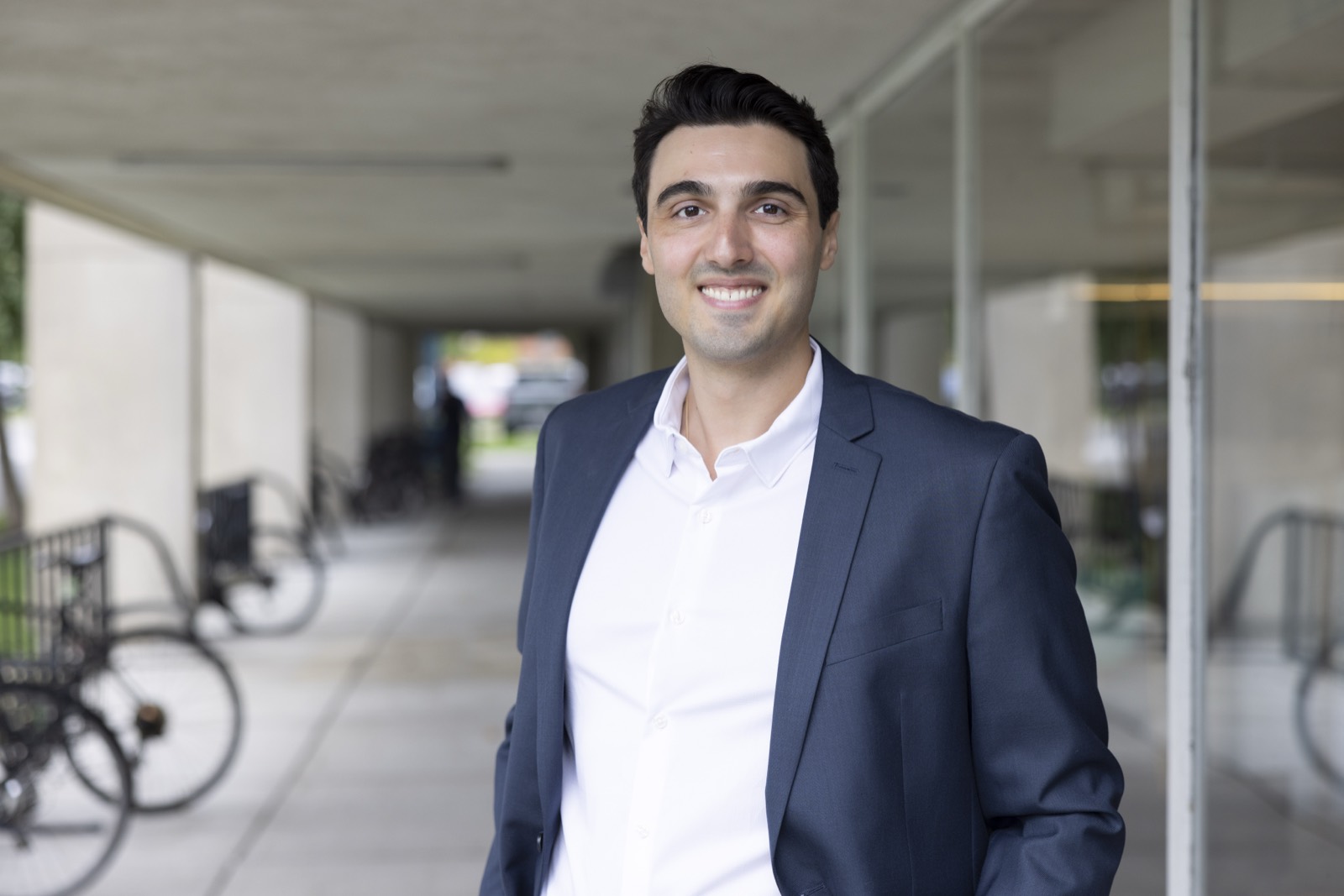 Stamatios Liapis, smiling, in a navy blazer in the Enlaye office